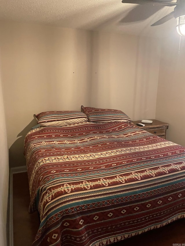 bedroom with a textured ceiling and ceiling fan