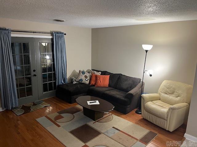 living room with a textured ceiling, french doors, and wood finished floors