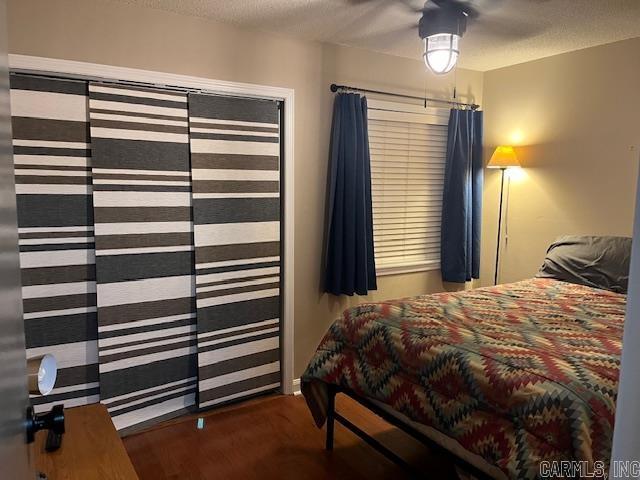 bedroom with a textured ceiling and wood finished floors