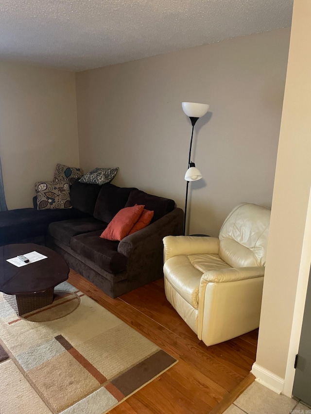 living room with a textured ceiling and hardwood / wood-style floors