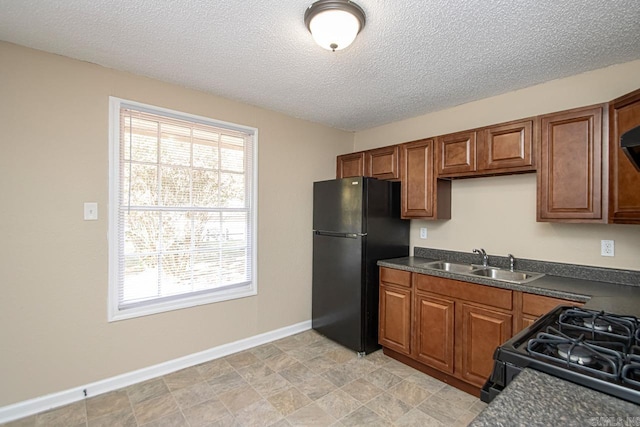 kitchen with a textured ceiling, black appliances, and sink