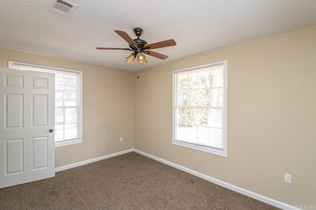 carpeted spare room with ceiling fan and a textured ceiling