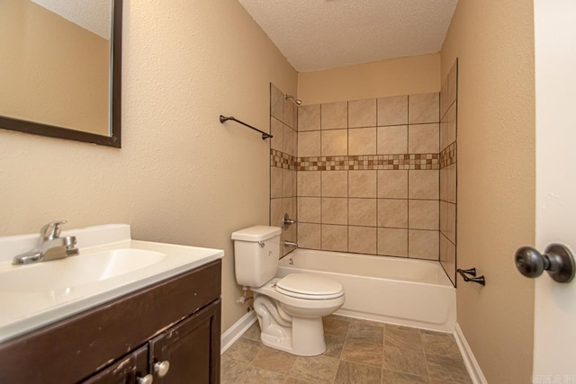 full bathroom featuring toilet, a textured ceiling, tiled shower / bath combo, and vanity