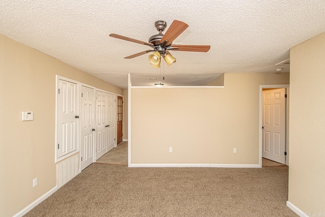 spare room featuring light carpet, a textured ceiling, and ceiling fan