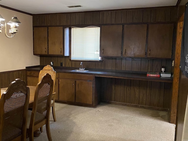 kitchen with light colored carpet, dark brown cabinetry, and sink