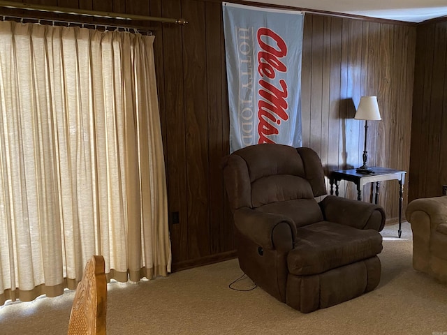 living area with light carpet and wooden walls