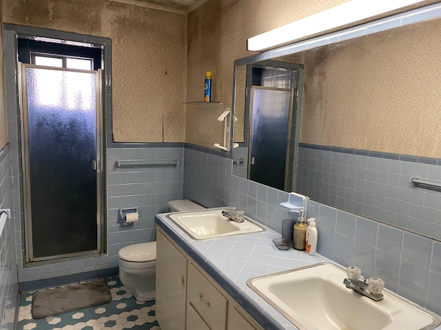 bathroom with an enclosed shower, vanity, tile walls, tile patterned flooring, and toilet