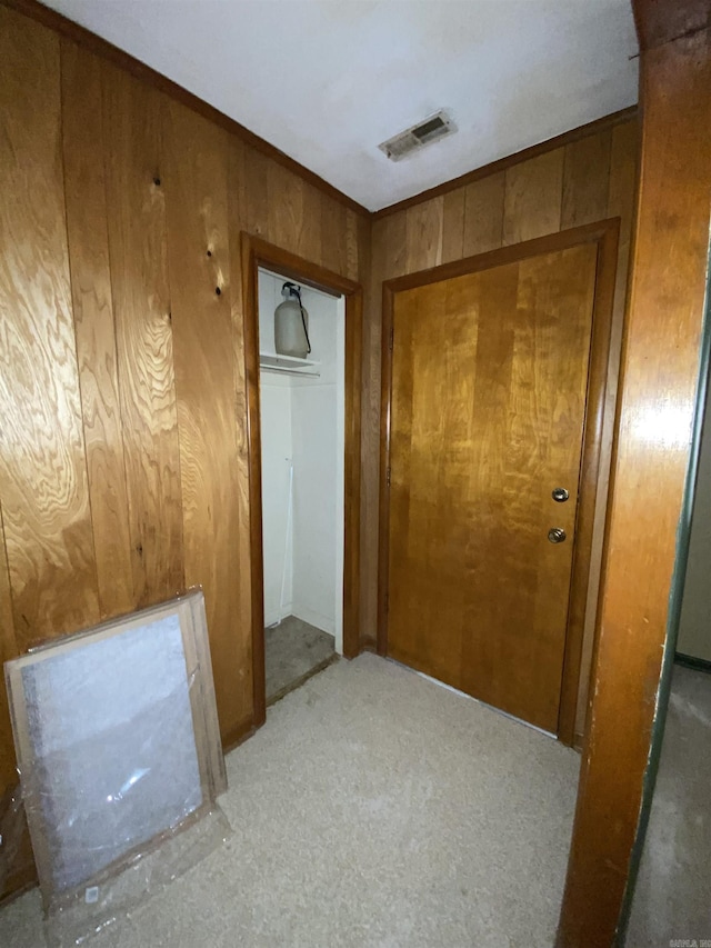 hallway featuring wooden walls