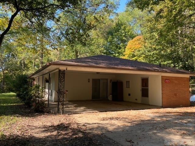 back of house featuring a carport