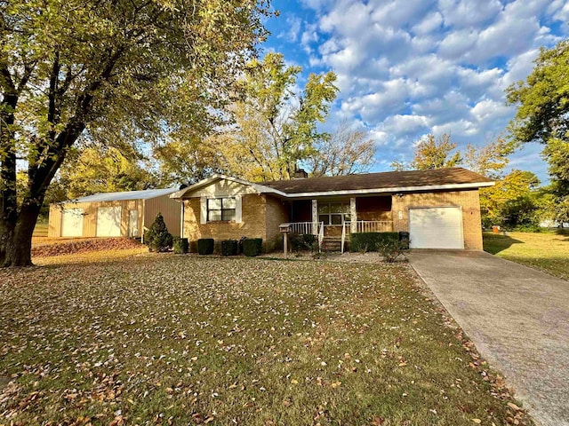 single story home featuring covered porch, a front yard, and a garage