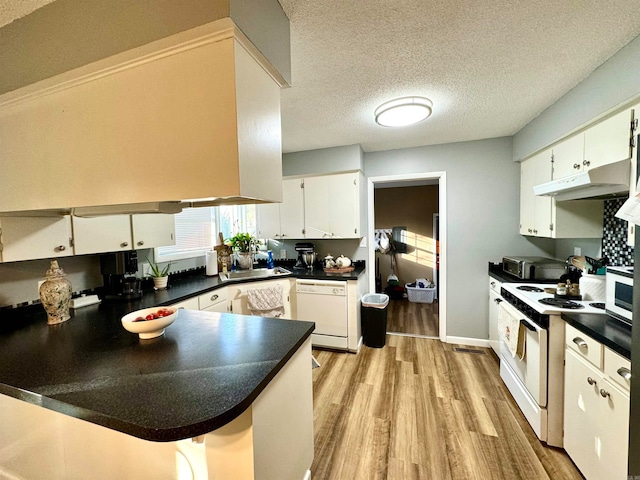 kitchen with white appliances, a textured ceiling, kitchen peninsula, white cabinetry, and light hardwood / wood-style flooring