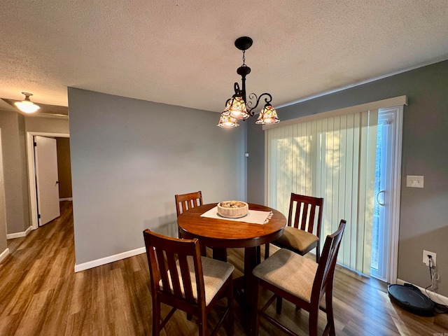 dining space featuring a notable chandelier, a textured ceiling, and dark hardwood / wood-style flooring