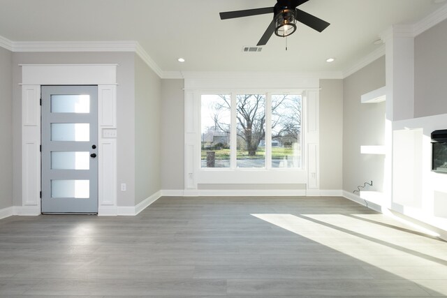 foyer entrance with ornamental molding, ceiling fan, and light wood-type flooring