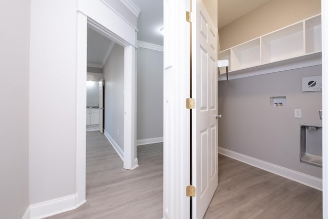 laundry room featuring washer hookup, ornamental molding, and light hardwood / wood-style floors