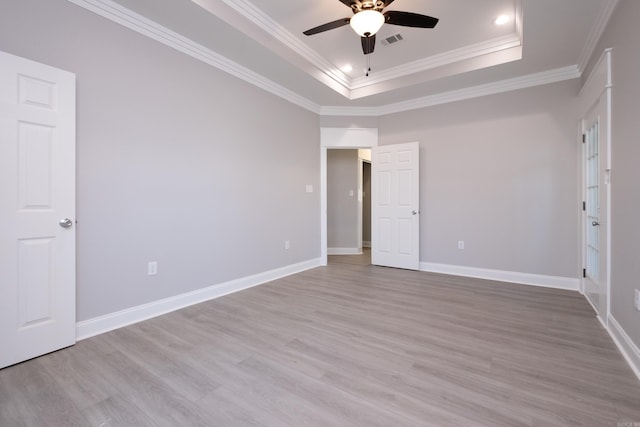 unfurnished bedroom with a raised ceiling, ornamental molding, ceiling fan, and light hardwood / wood-style floors