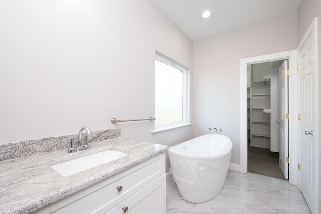 bathroom featuring a tub to relax in and vanity