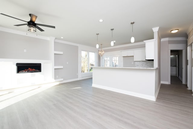 unfurnished living room with ornamental molding, light hardwood / wood-style floors, and ceiling fan
