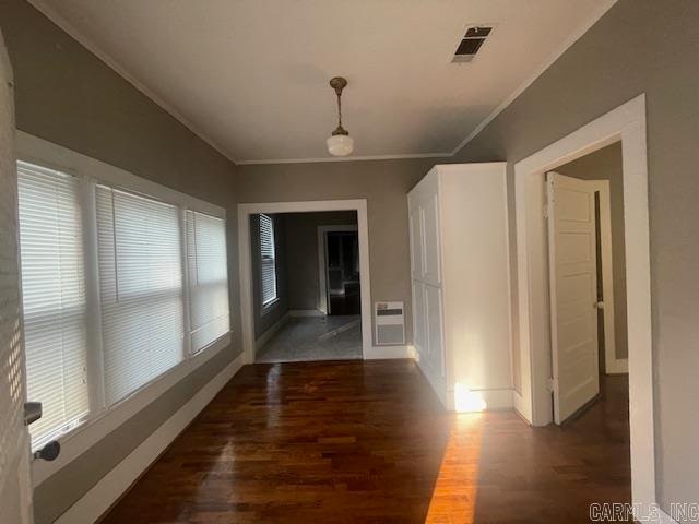 hallway featuring ornamental molding, dark hardwood / wood-style floors, and plenty of natural light