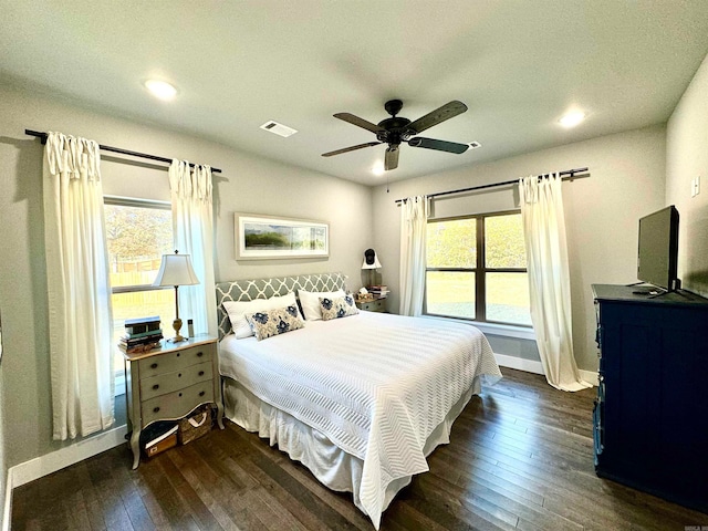 bedroom featuring dark wood-type flooring, multiple windows, and ceiling fan