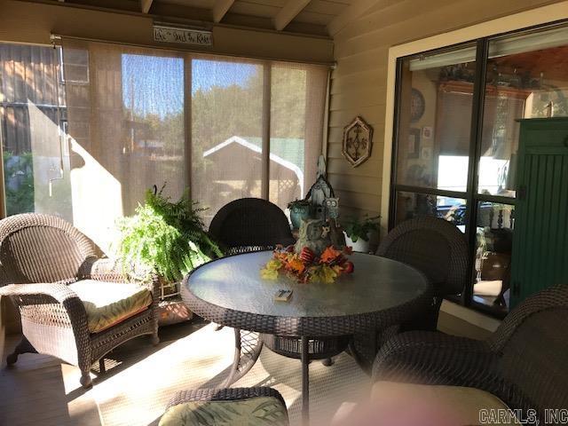 sunroom / solarium featuring outdoor dining area and wood finished floors