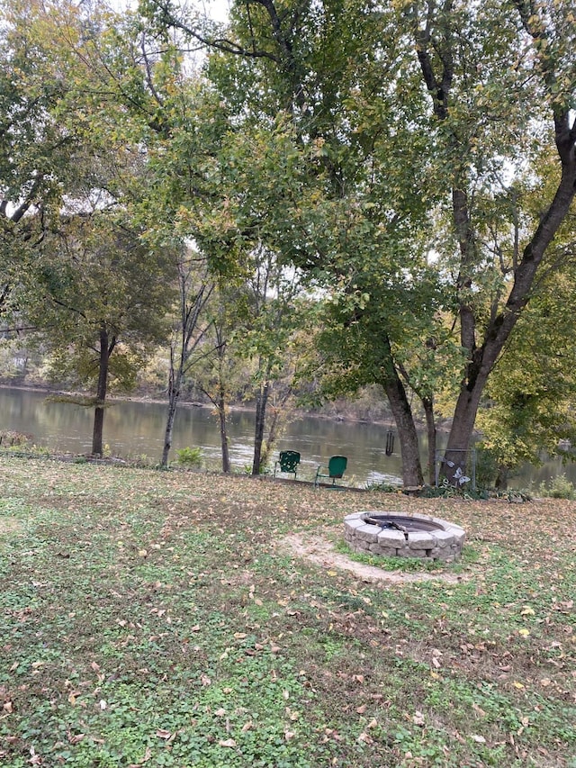 view of yard featuring a water view and a fire pit