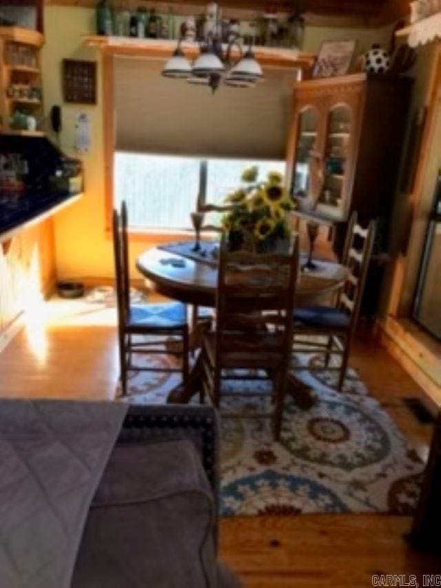 dining area with hardwood / wood-style floors and a chandelier