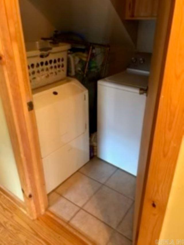 laundry area featuring light tile patterned floors, laundry area, and washing machine and dryer
