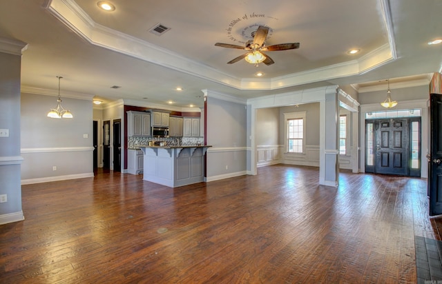 unfurnished living room with crown molding, dark hardwood / wood-style floors, and a raised ceiling