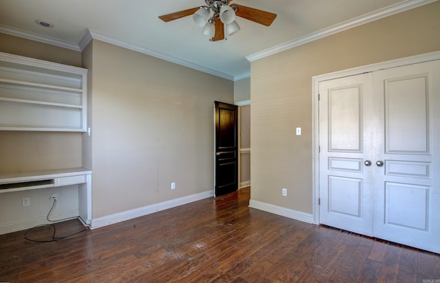 unfurnished bedroom featuring ornamental molding, ceiling fan, built in desk, and dark hardwood / wood-style flooring