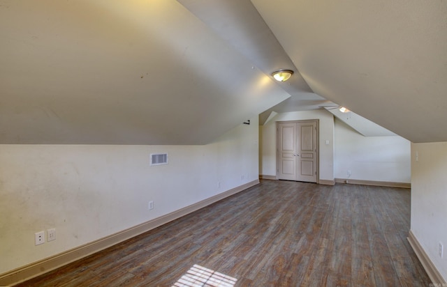 additional living space with hardwood / wood-style flooring and vaulted ceiling