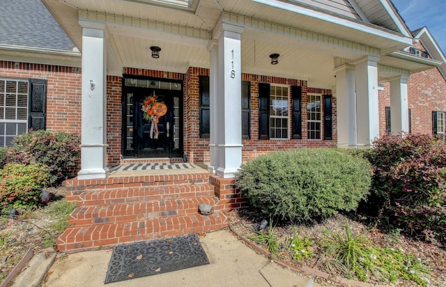 view of exterior entry featuring covered porch