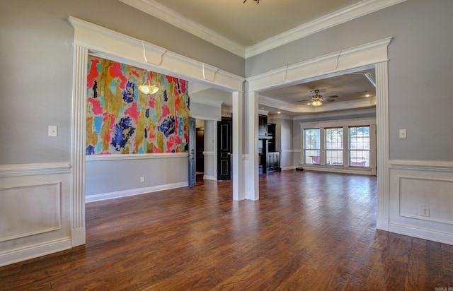 empty room featuring dark wood-type flooring, ceiling fan, and ornamental molding