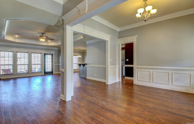 spare room with ceiling fan with notable chandelier, ornamental molding, a tray ceiling, and dark hardwood / wood-style floors