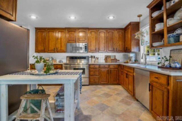 kitchen with a breakfast bar area, sink, appliances with stainless steel finishes, and decorative light fixtures