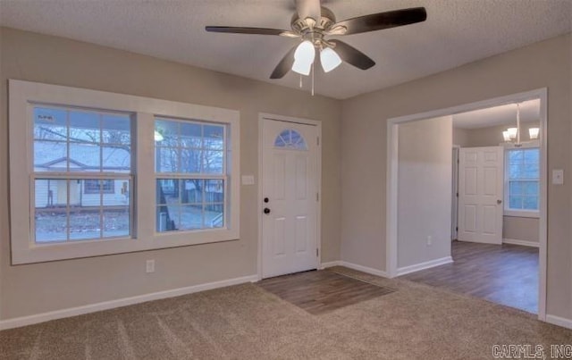 carpeted entryway featuring ceiling fan and a textured ceiling