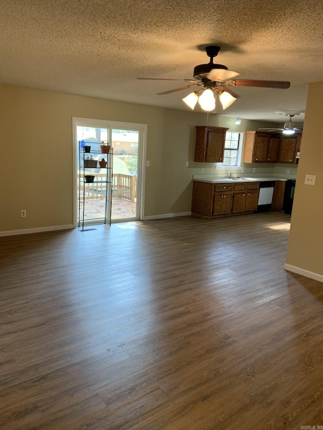 interior space with a textured ceiling, ceiling fan, dark hardwood / wood-style flooring, and sink