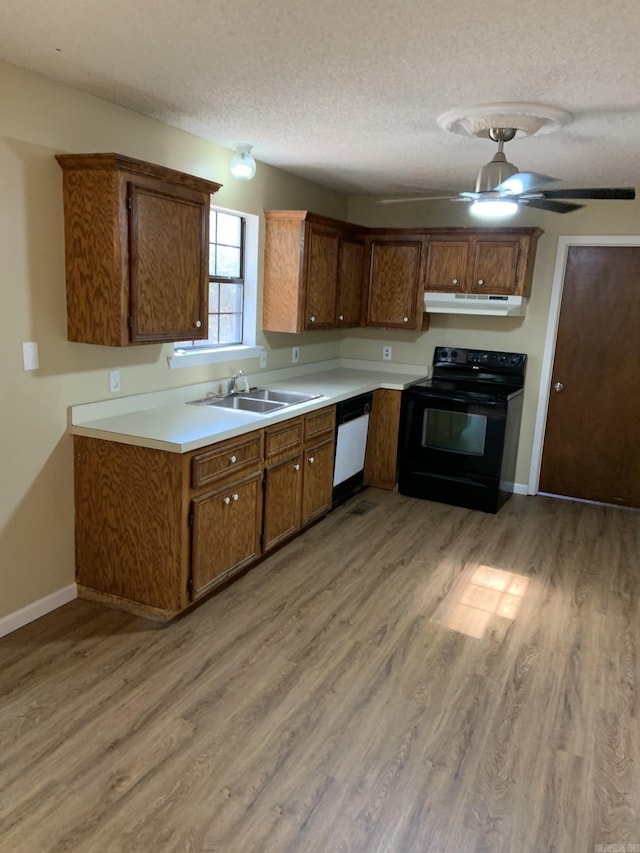 kitchen with white dishwasher, black range with electric stovetop, sink, a textured ceiling, and light hardwood / wood-style floors