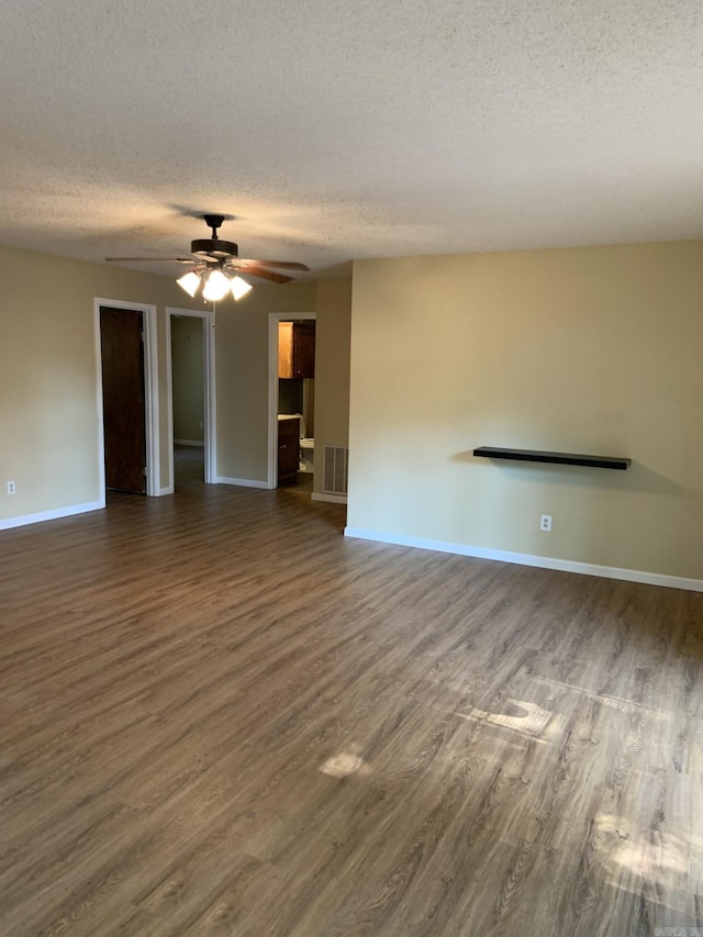 unfurnished living room featuring a textured ceiling, dark hardwood / wood-style flooring, and ceiling fan