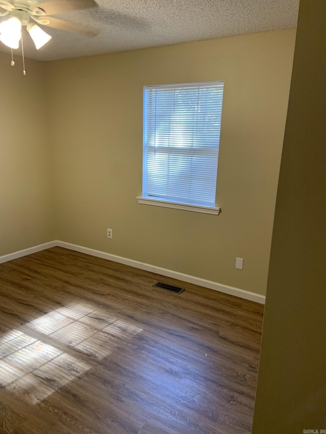 unfurnished room with hardwood / wood-style floors, a textured ceiling, and ceiling fan