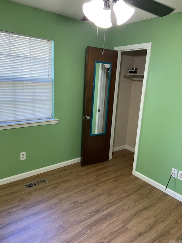 unfurnished bedroom featuring hardwood / wood-style floors, a textured ceiling, a closet, and ceiling fan