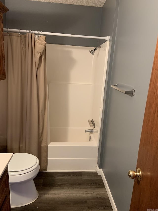 full bathroom featuring hardwood / wood-style floors, vanity, toilet, and a textured ceiling