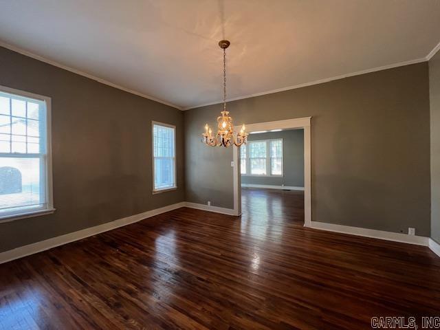 919 E Hamilton Ave, Wynne, AR 72396 - unfurnished dining area featuring crown molding, dark wood-style flooring, baseboards, and an inviting chandelier