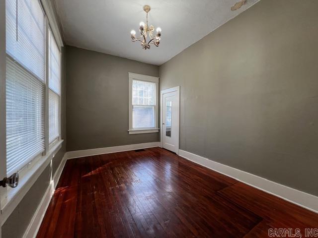 919 E Hamilton Ave, Wynne, AR 72396 - unfurnished room featuring baseboards, a notable chandelier, and hardwood / wood-style flooring