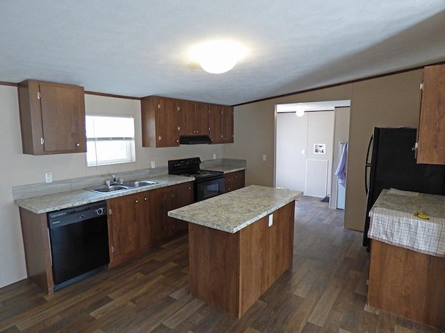 kitchen featuring dark hardwood / wood-style floors, black appliances, sink, crown molding, and a center island