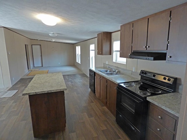 kitchen featuring a kitchen island, a textured ceiling, dark hardwood / wood-style floors, black appliances, and sink