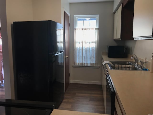 kitchen with sink, black appliances, white cabinets, and dark hardwood / wood-style floors