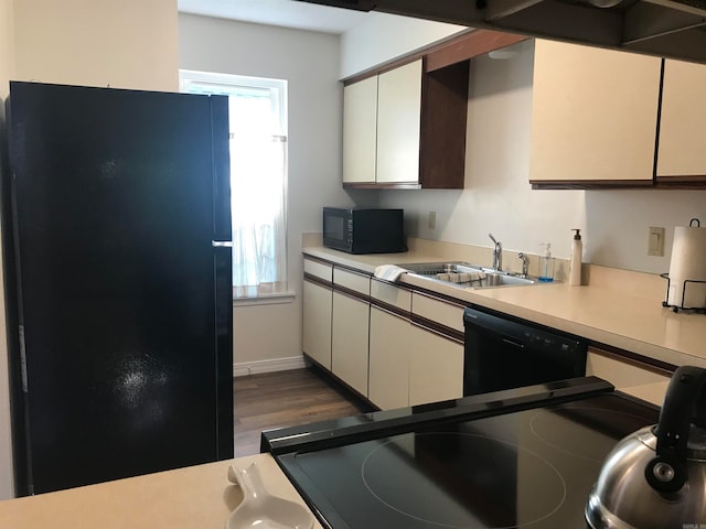 kitchen featuring sink, black appliances, white cabinetry, and dark hardwood / wood-style floors