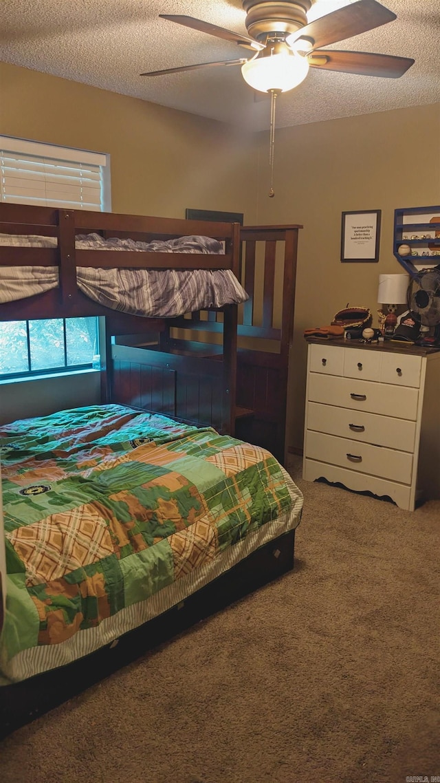 carpeted bedroom featuring a textured ceiling and ceiling fan