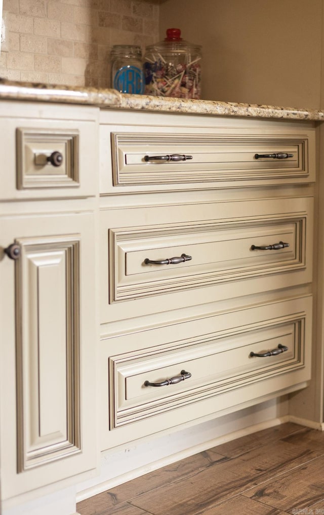 details featuring wood-type flooring and backsplash