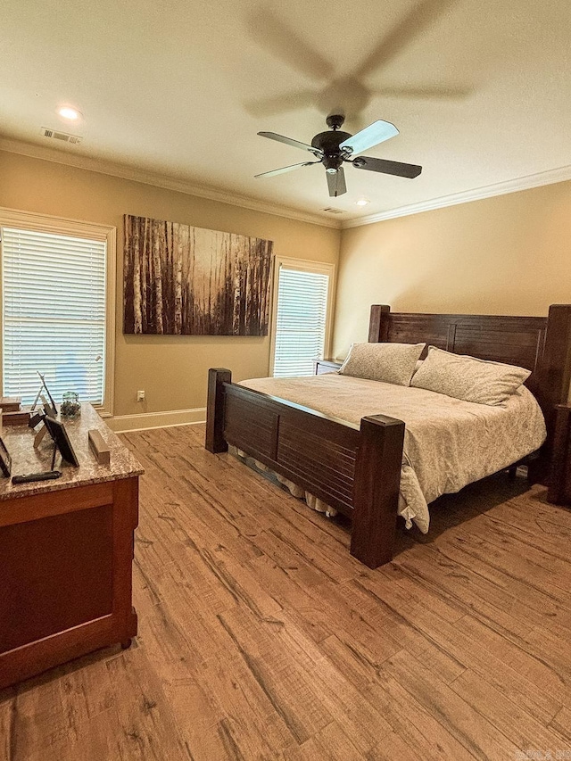 bedroom featuring crown molding, light hardwood / wood-style flooring, and ceiling fan